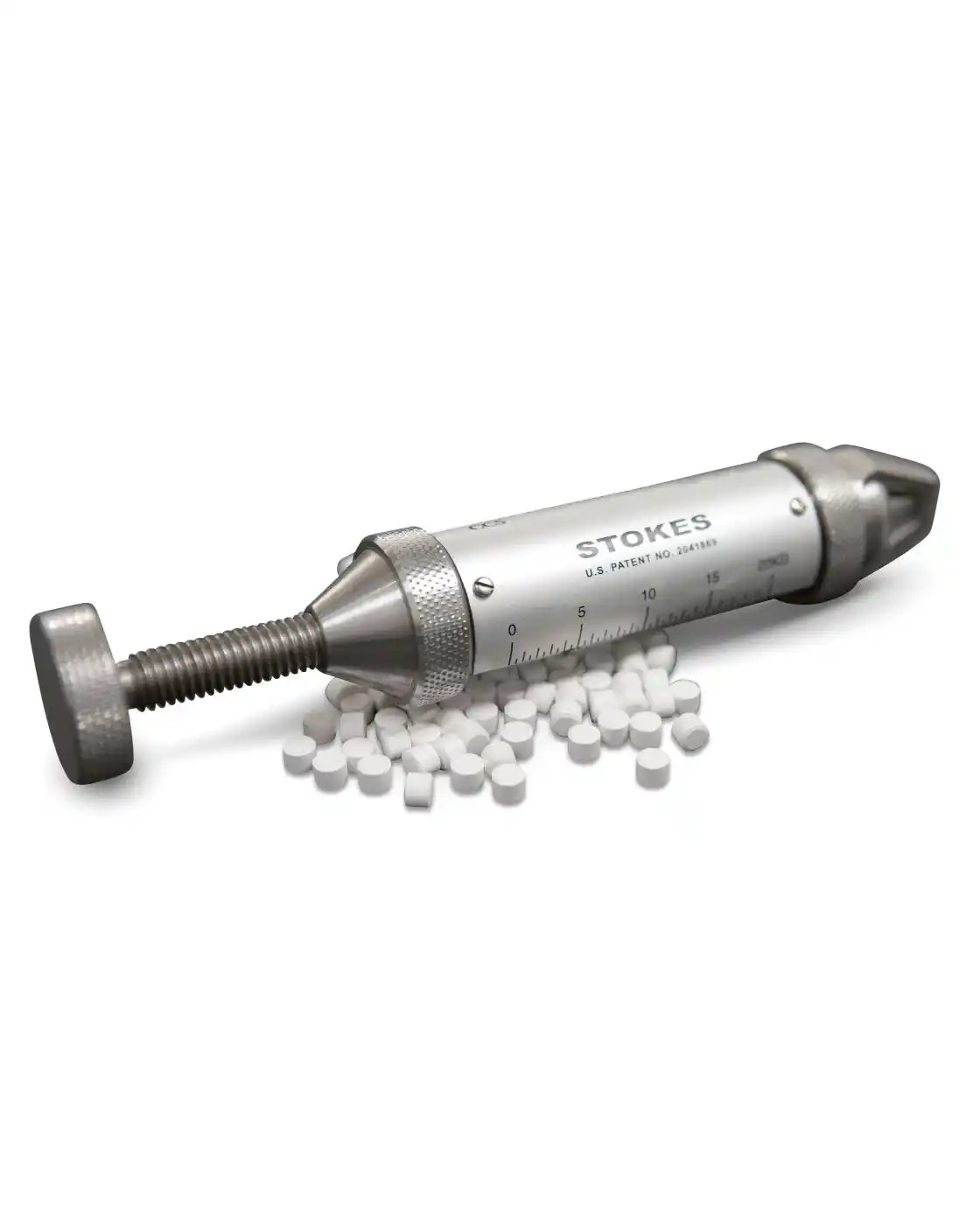 Stokes Tablet Hardness Tester resting atop of white tablets.