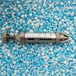 Stokes Tablet Hardness Tester against a bed of white and blue tablets.